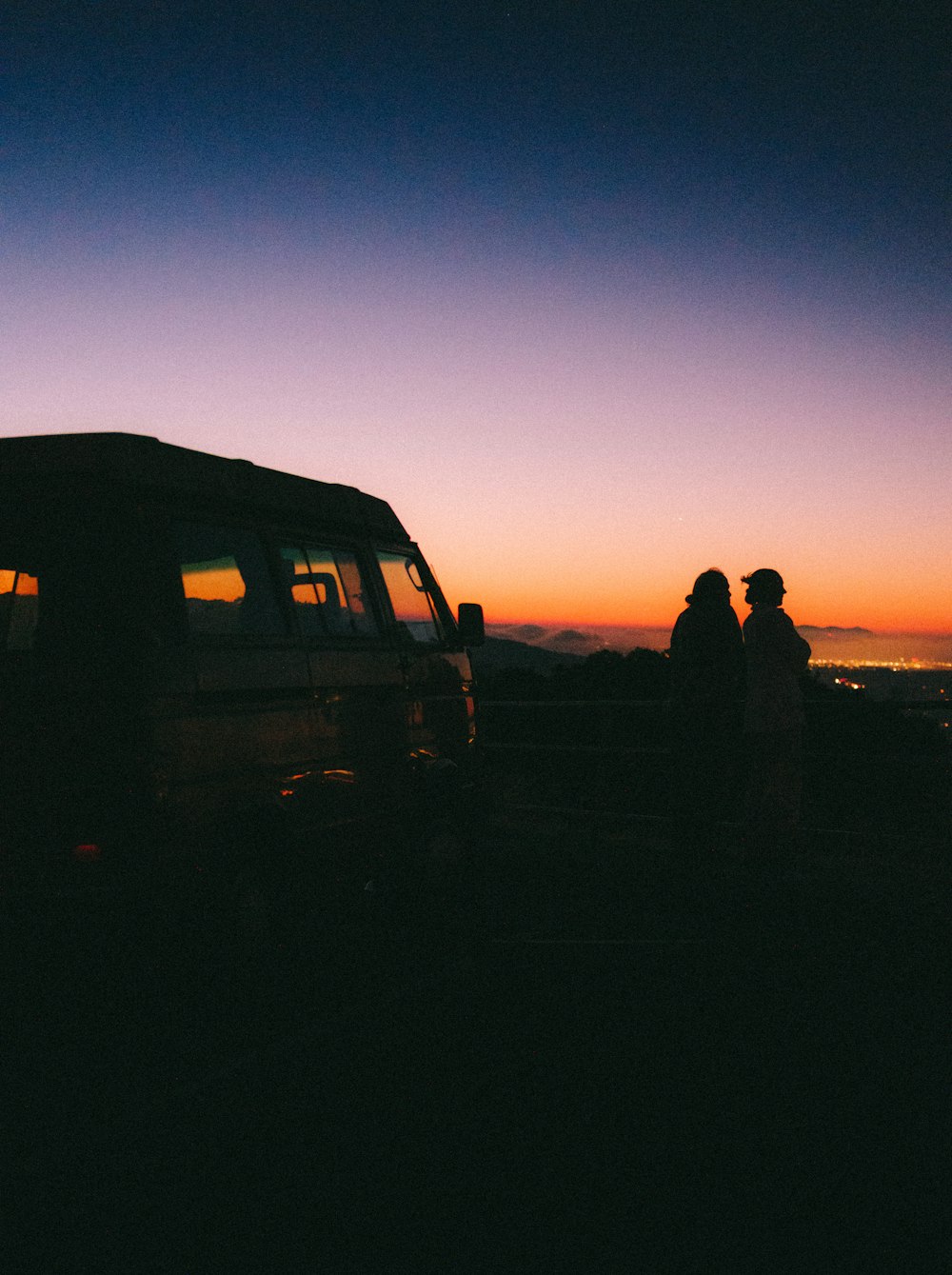 a group of people standing next to a van at night