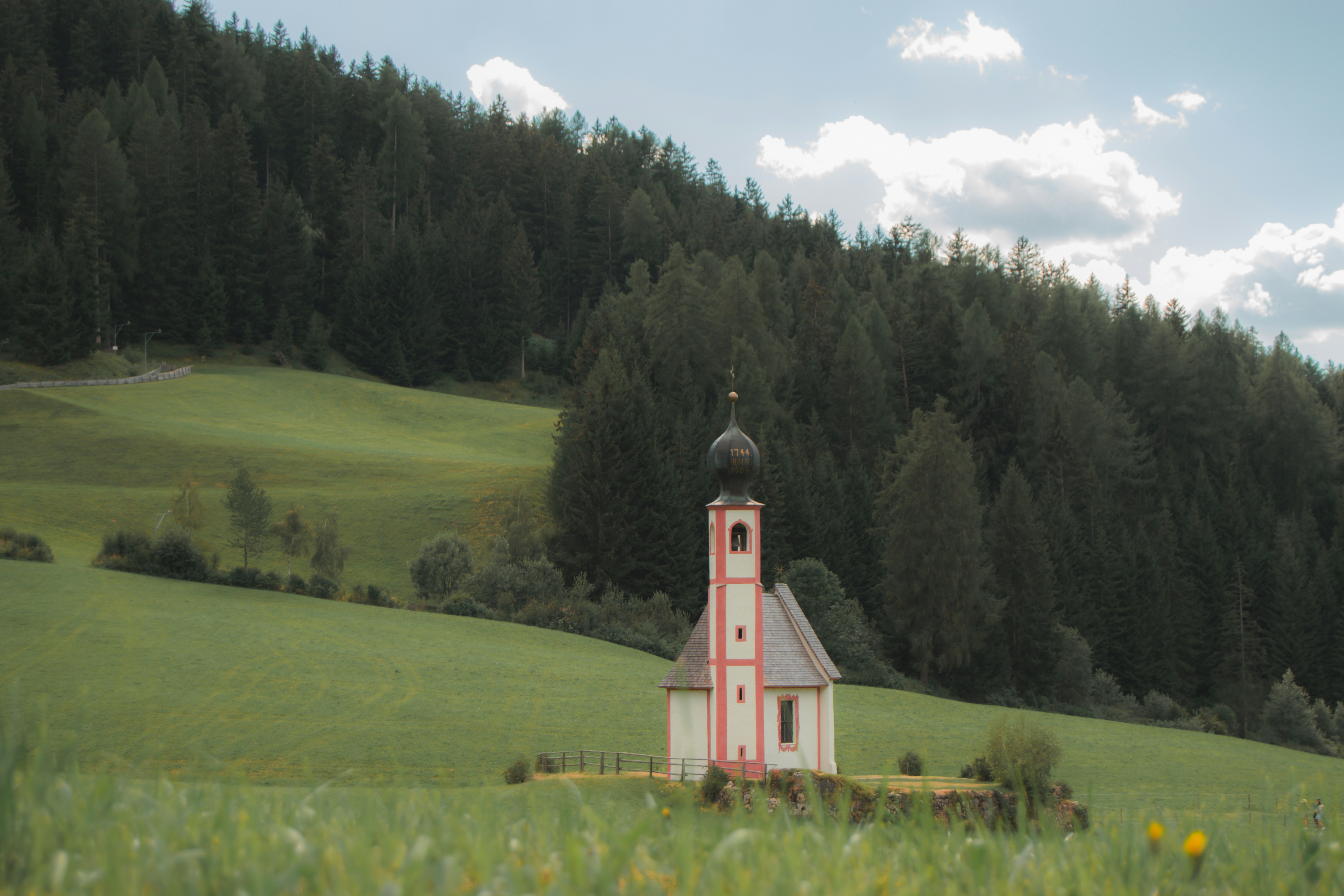eine kleine Kirche auf einem grasbewachsenen Feld