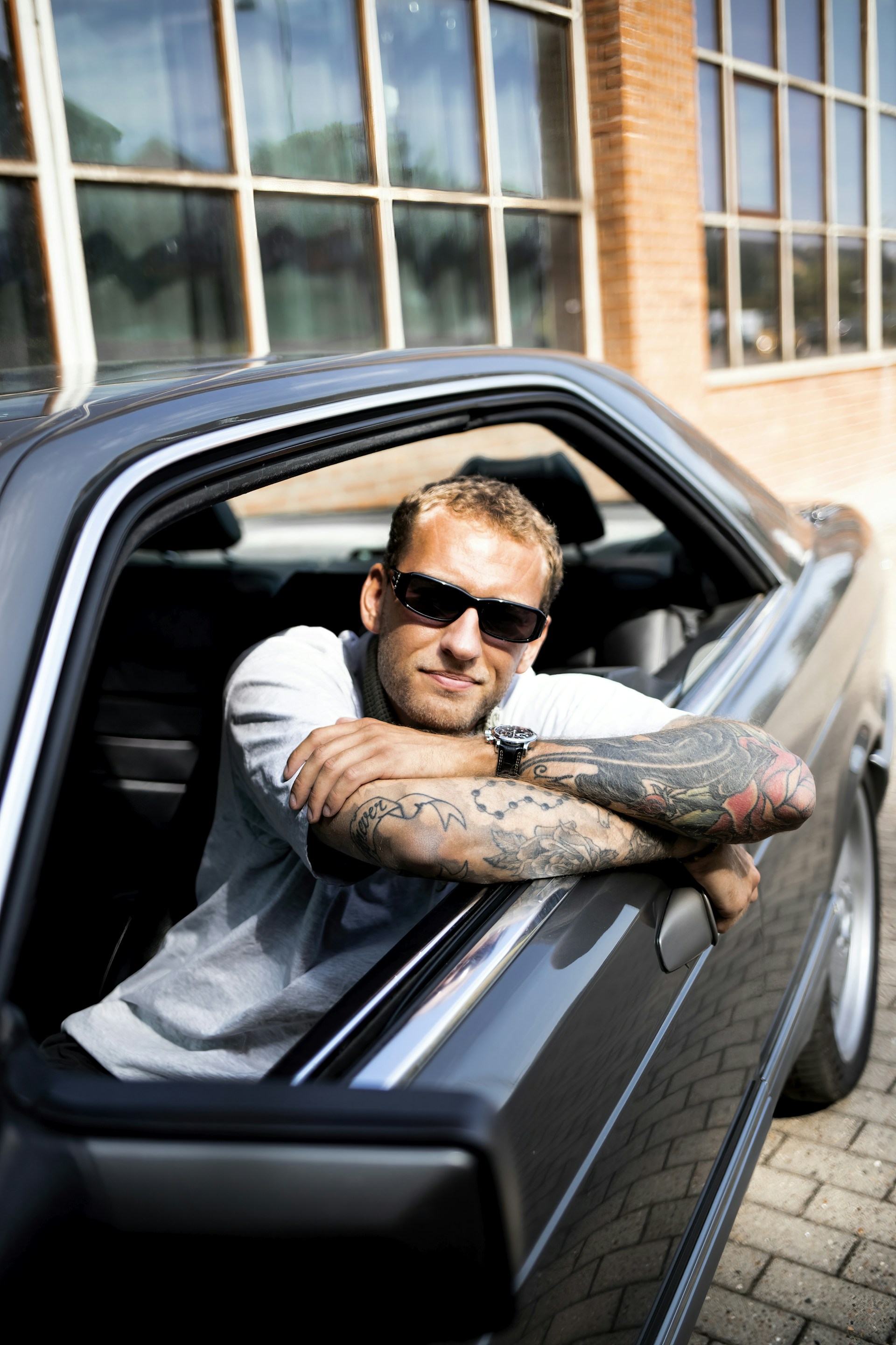 a person with tattoos in a car