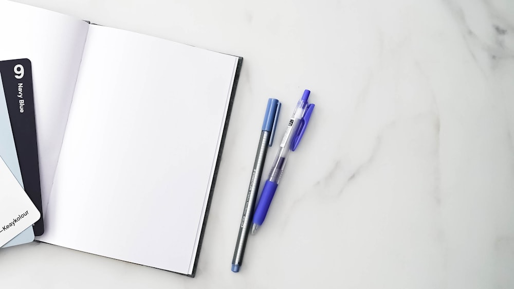 a group of pens on a white surface