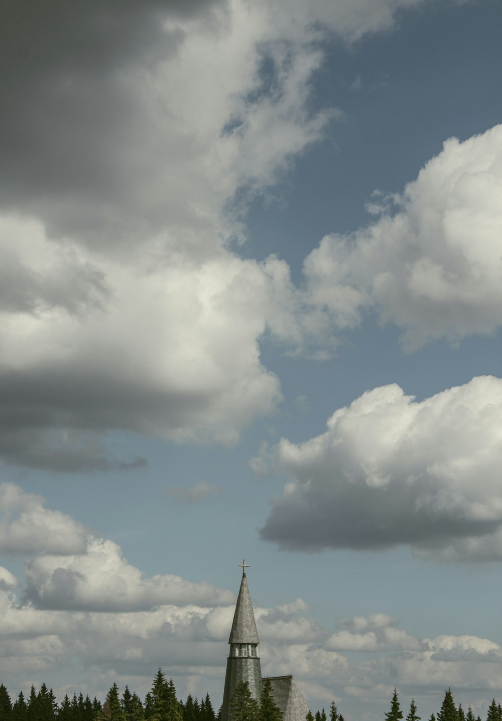 a tall tower with clouds above it