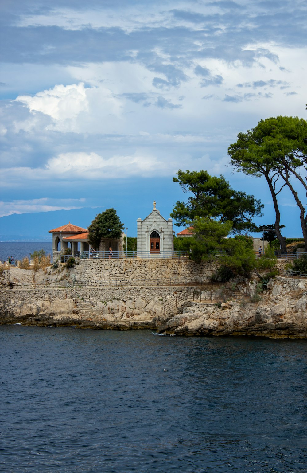 a building on a rocky cliff by the water