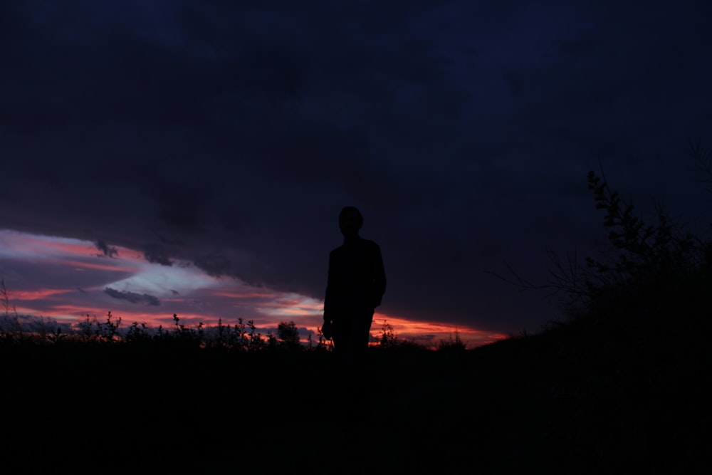 a person standing in front of a sunset