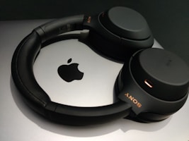 Stylish tech accessories including headphones and a mouse with orange highlights.