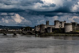 a castle on a hill by a river
