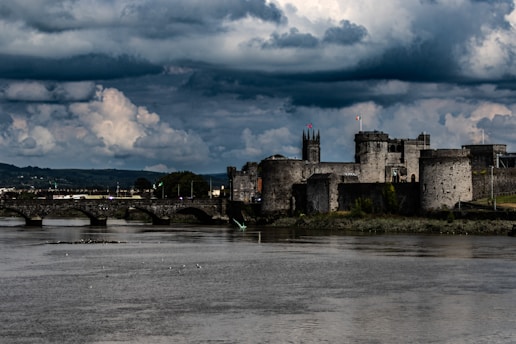 a castle on a hill by a river