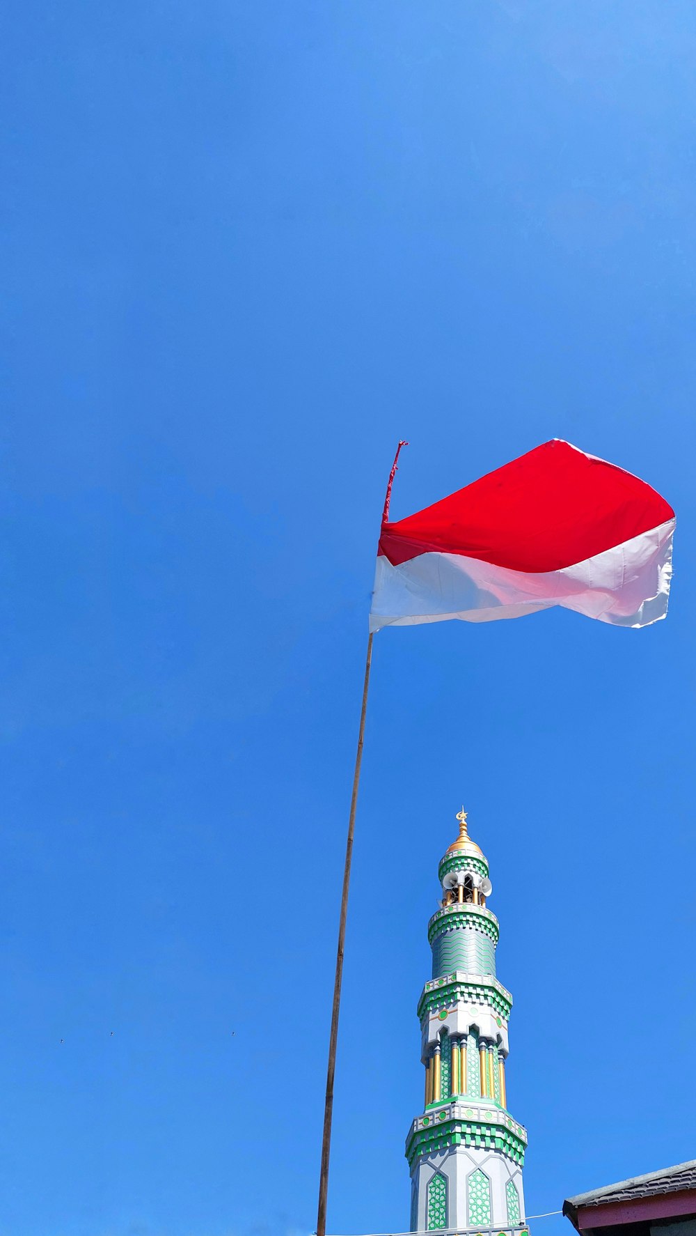 a couple of flags flying in front of a tall building