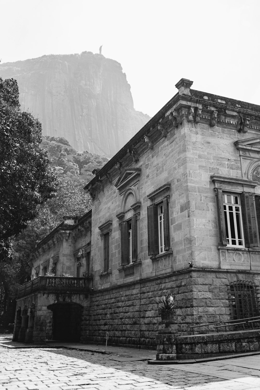 a stone building with a hill in the background