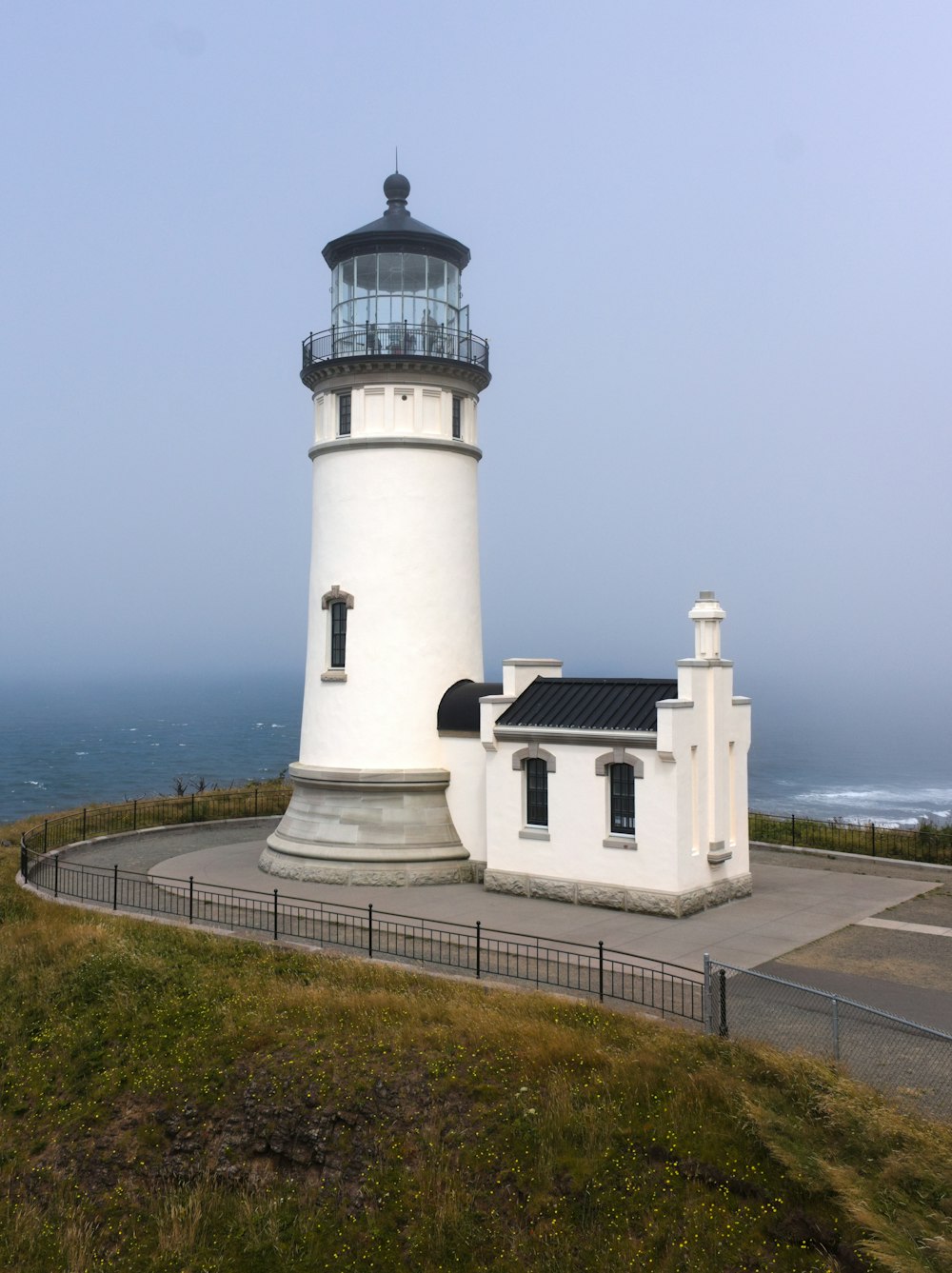 a white lighthouse on a hill