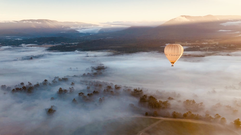 a hot air balloon flying over a large body of water