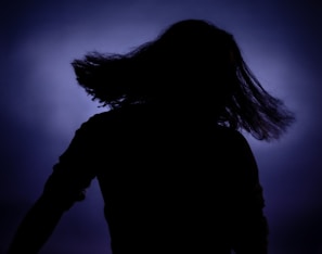 Vibrant gradient background with a sleek robotic arm styling hair under neon lights.