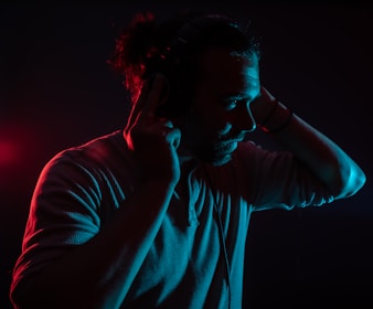 A user adjusting their ear plugs for optimal sound quality.