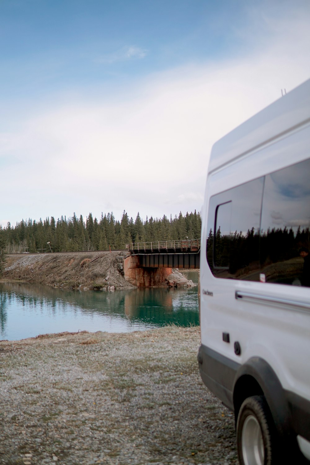 a bus driving on a road next to a body of water