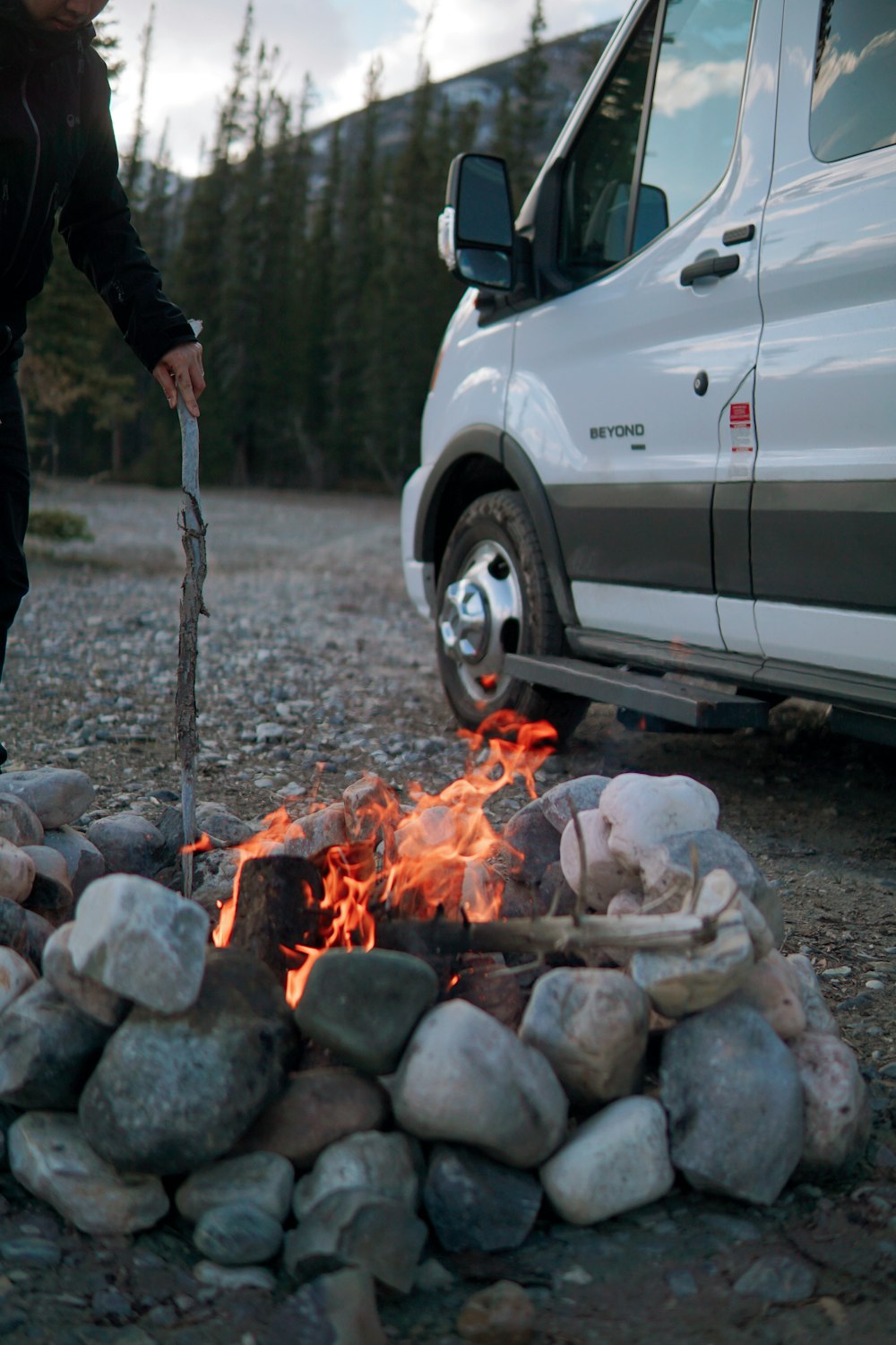 a person standing next to a campfire