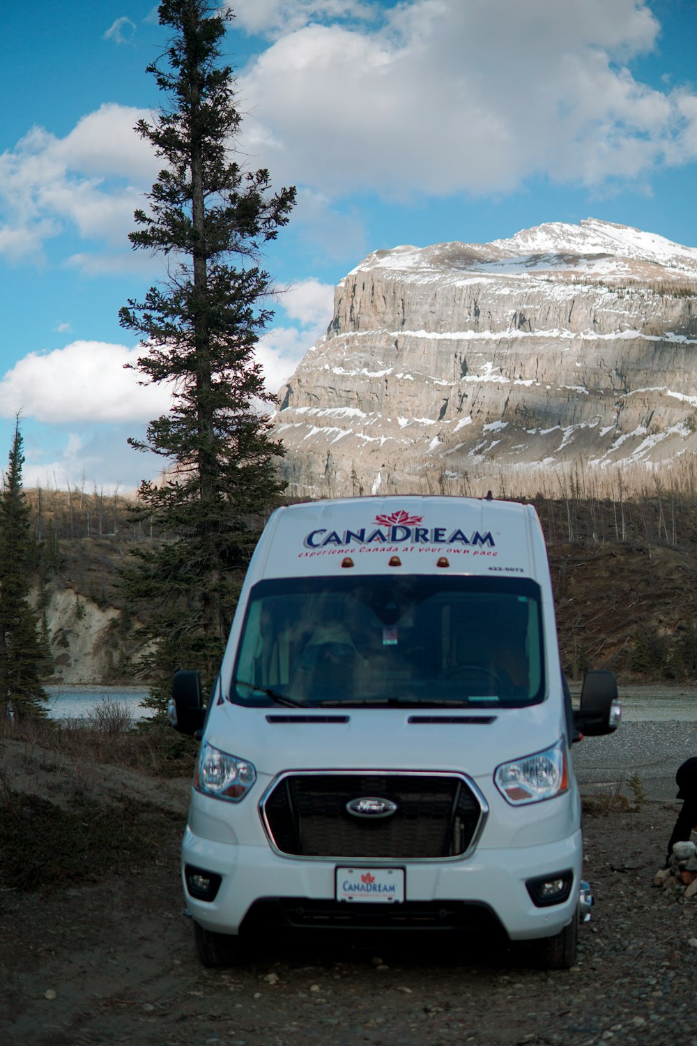 a white van parked in front of a rocky mountain