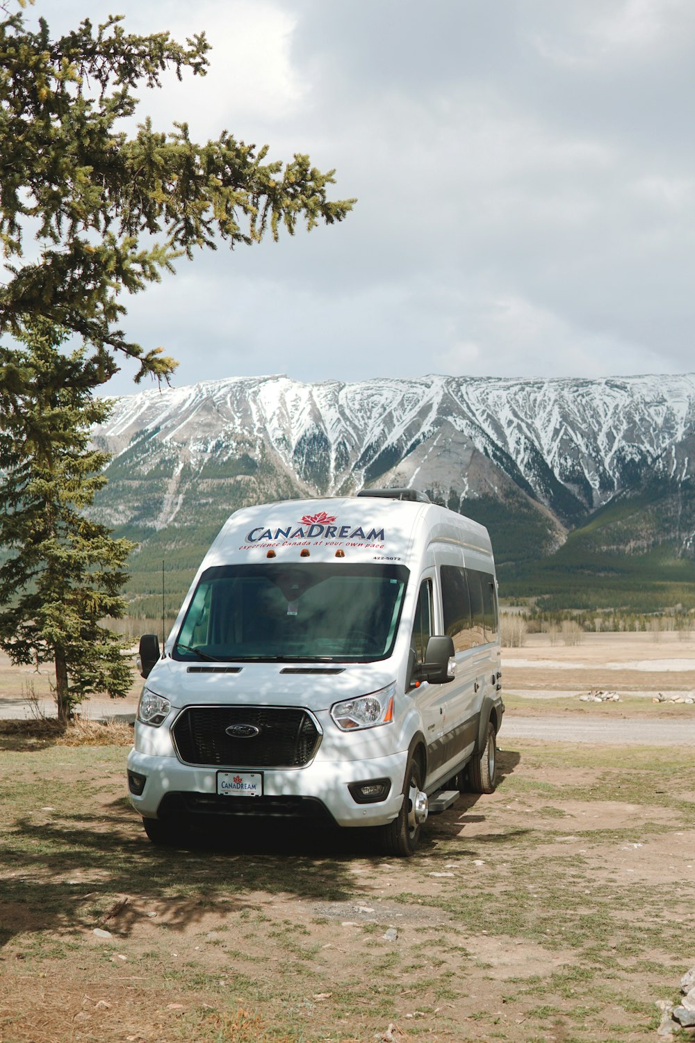 a white van parked in front of a snowy mountain