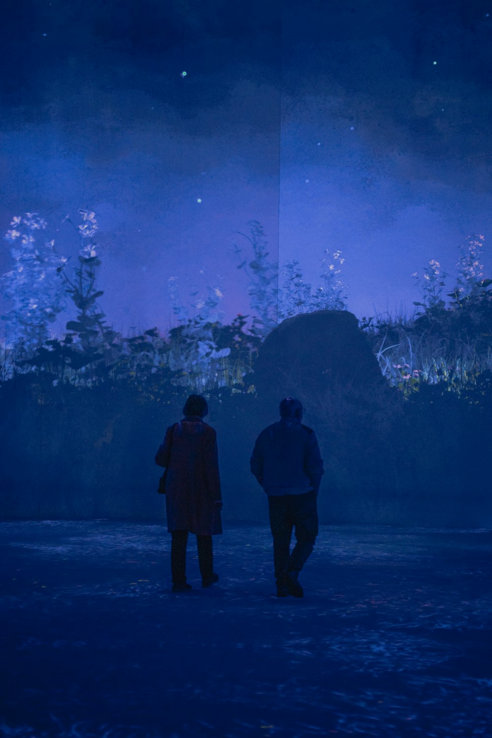 a man and woman looking at a large aquarium