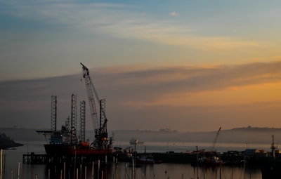 An offshore drilling platform at sunset with calm waters.