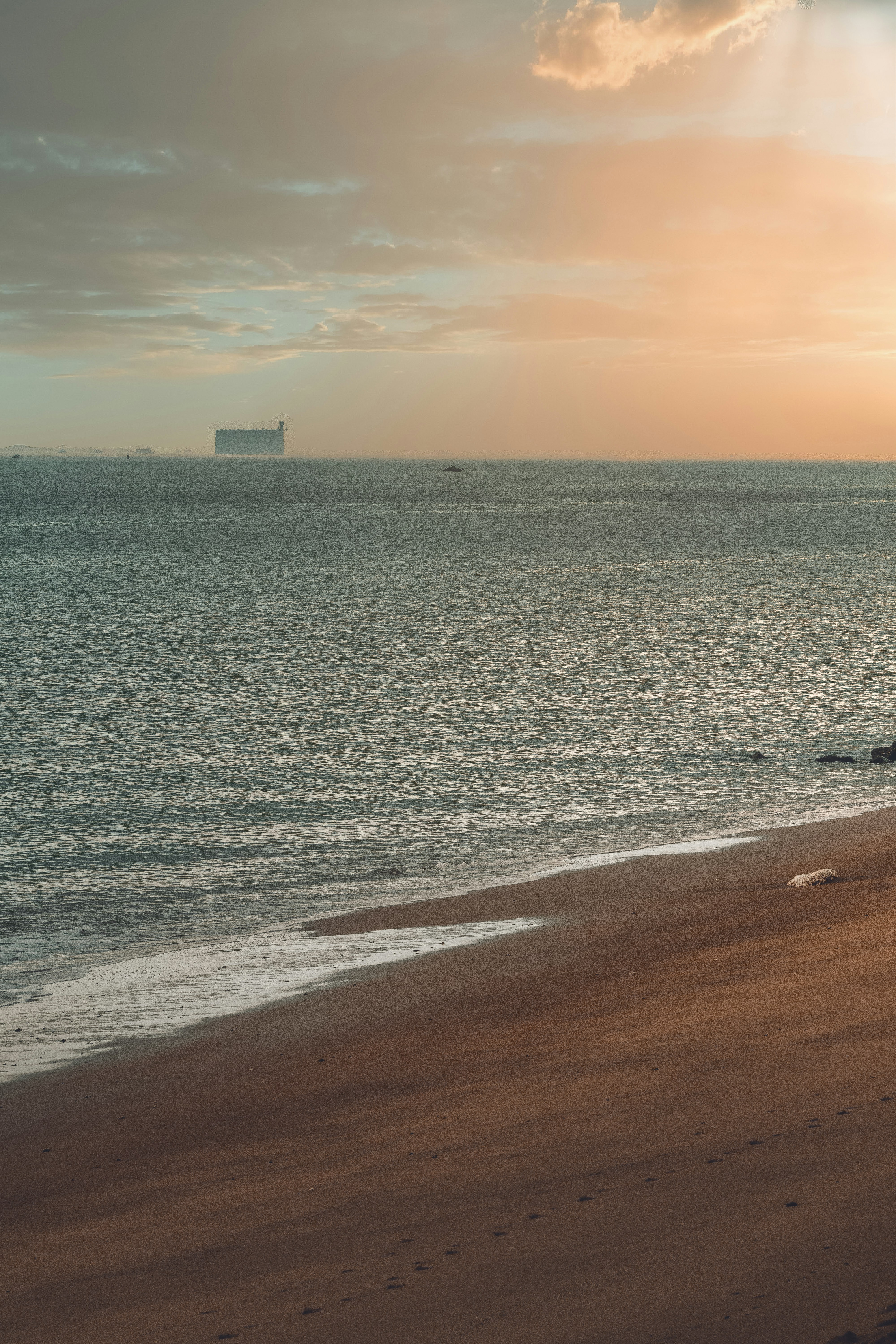 Ein Strand mit einem Gebäude in der Ferne