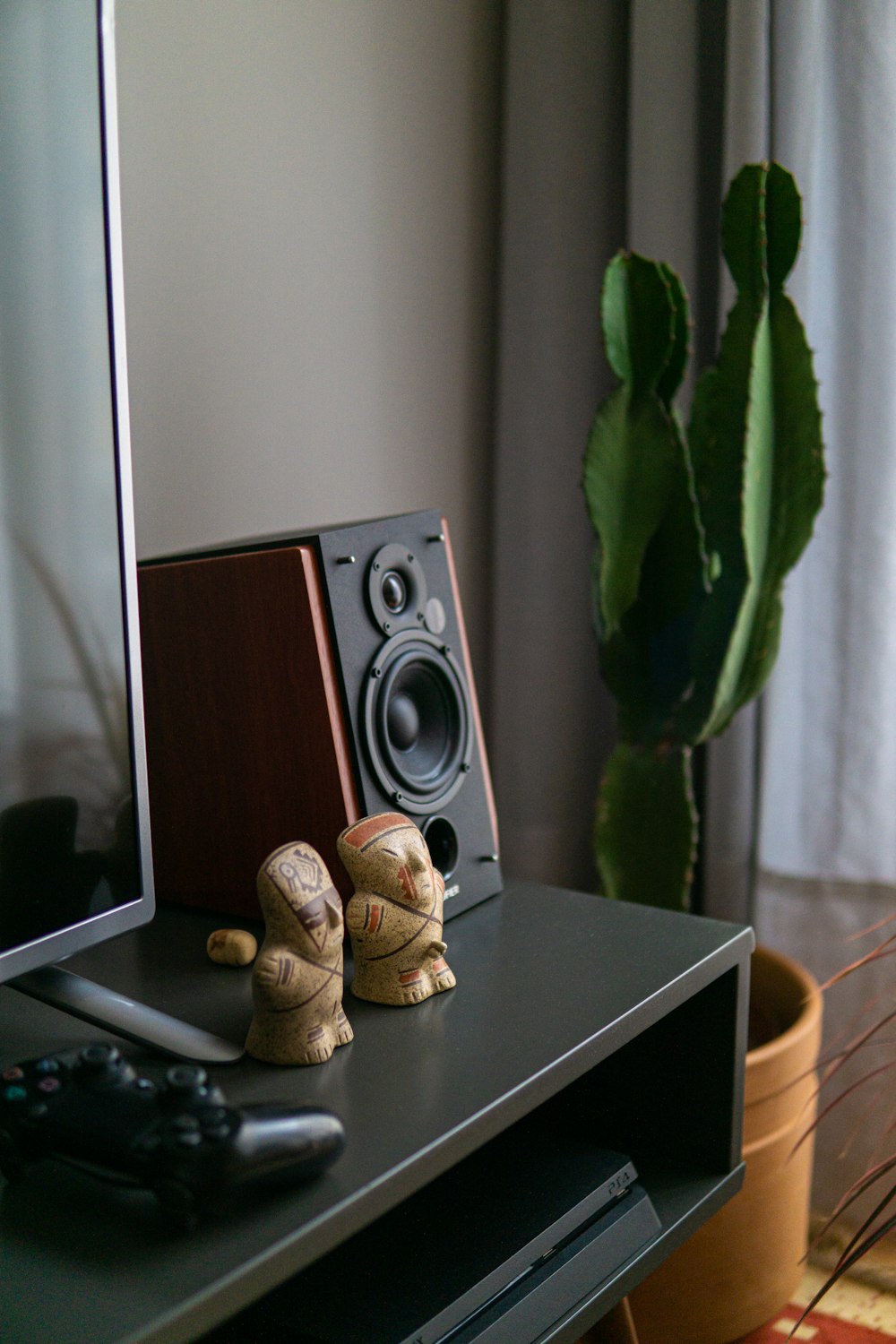 a black rectangular object with a black object on it next to a plant