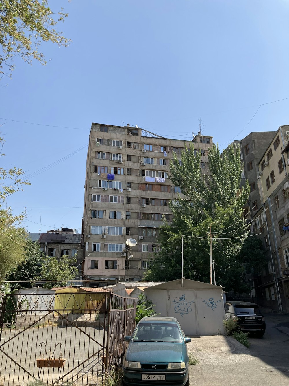 a building with a fence and cars parked in front of it