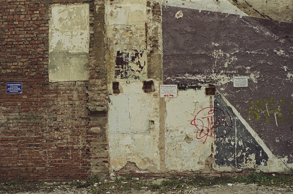 un mur de briques avec des graffitis dessus