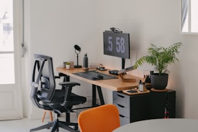a desk with a computer and a chair in a room