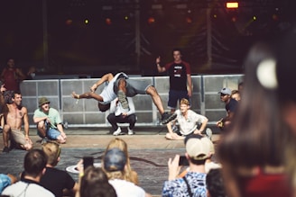 a person doing a flip on a stage with a crowd watching
