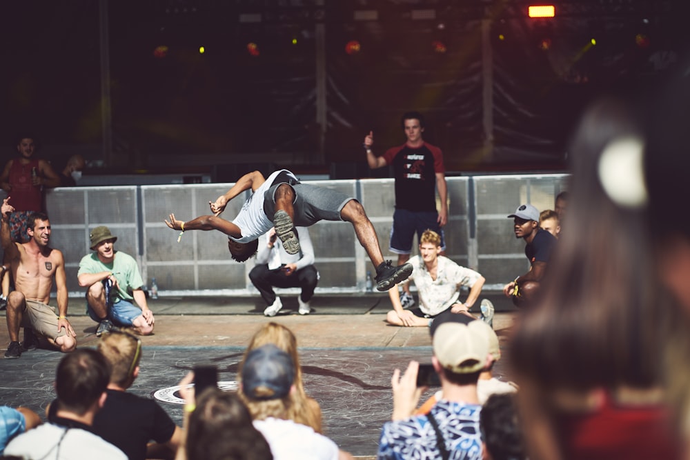 a person doing a flip on a stage with a crowd watching
