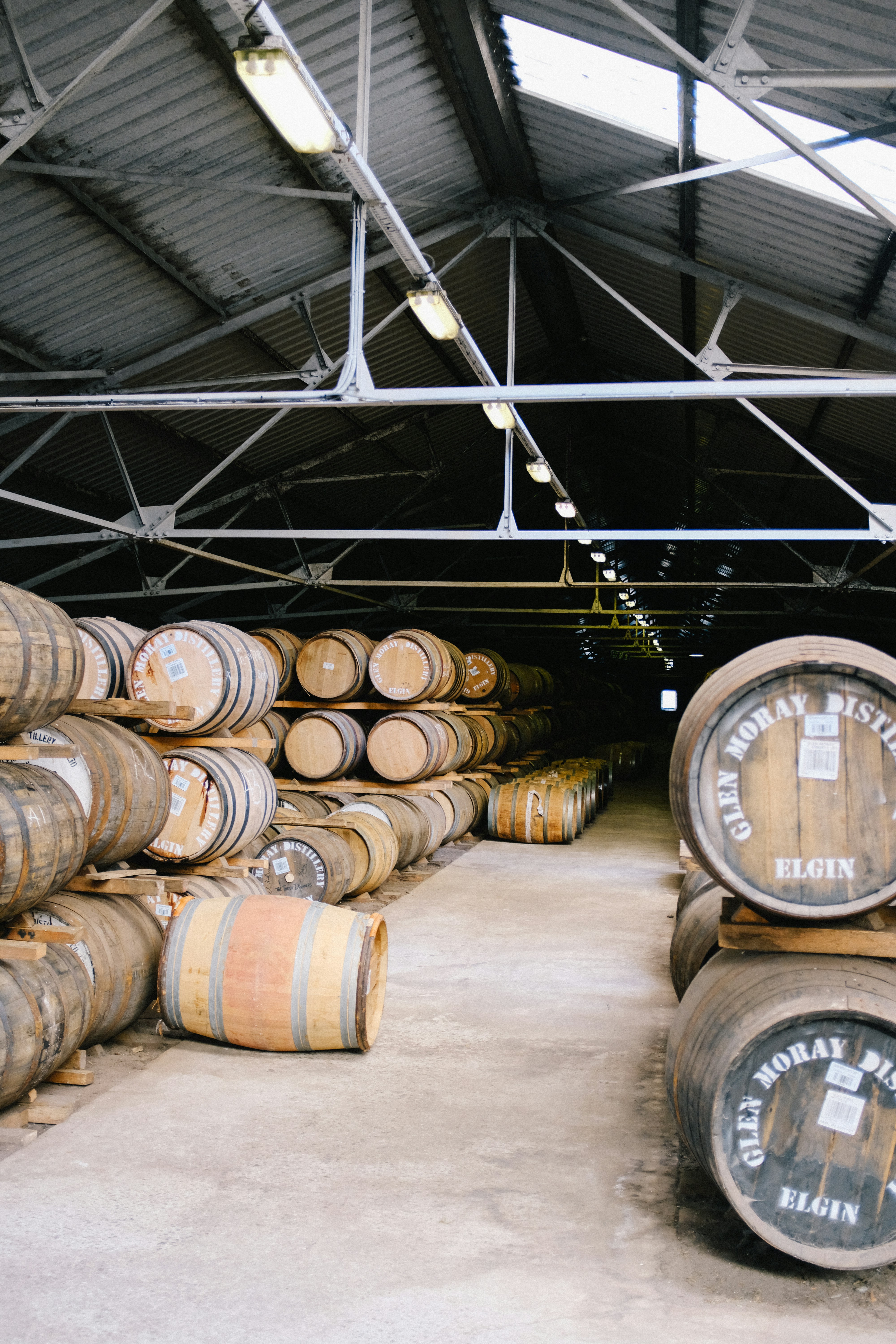 Industrial lubricant oil barrels and containers in dark warehouse storage, chemical products, low-key industrial lighting