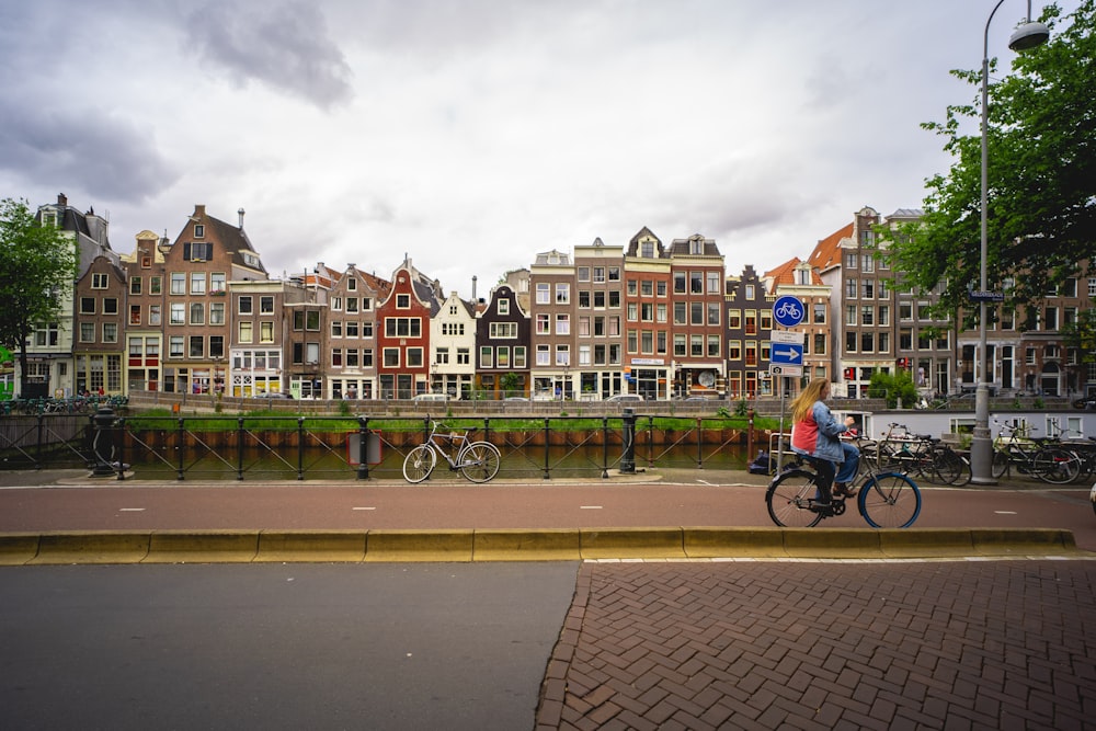 a person riding a bicycle on a street with buildings in the background