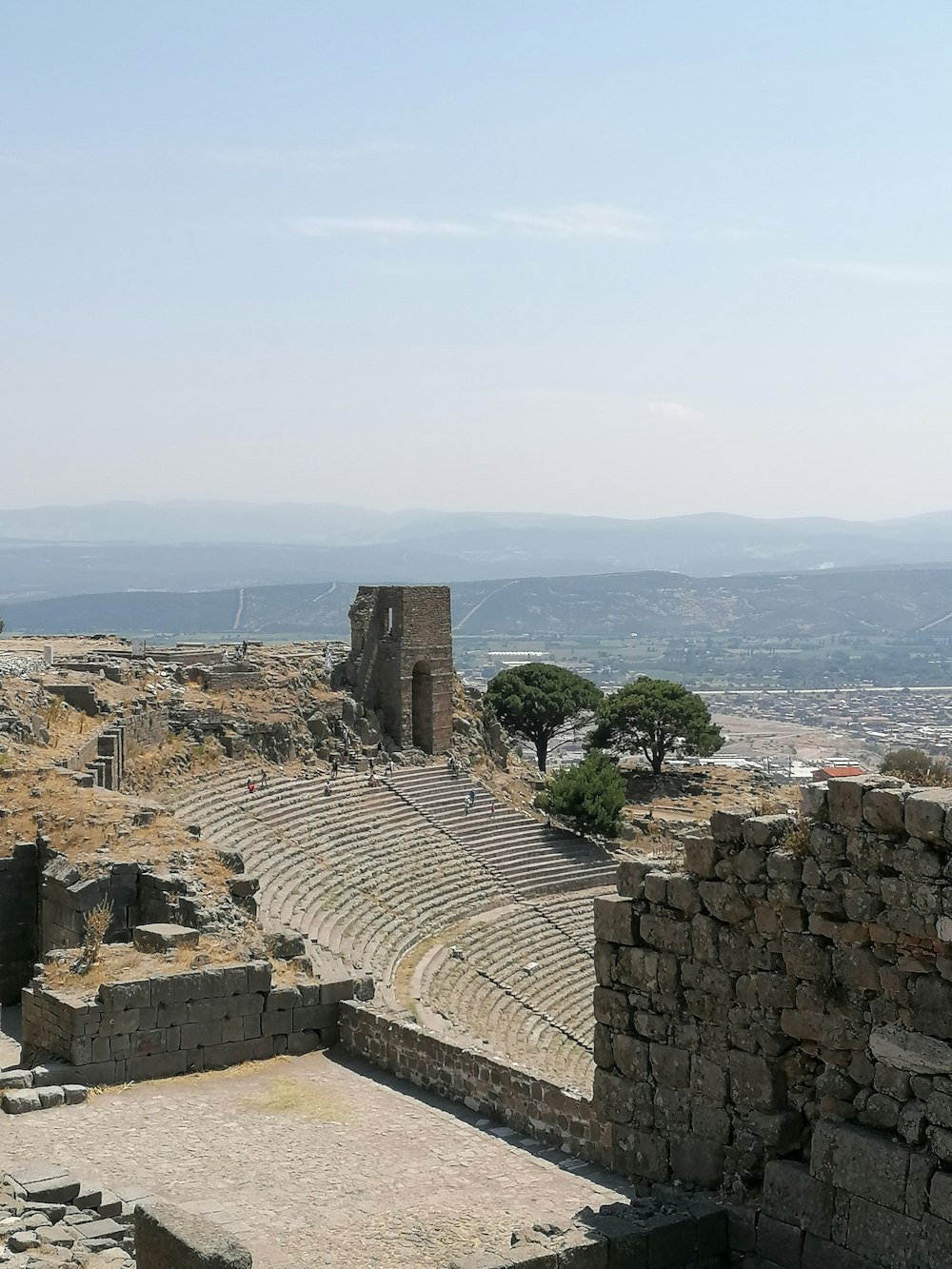 a stone wall with a city in the background