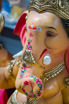 A sleek modern Ganesh statue with smooth curves and a minimalist gold finish.