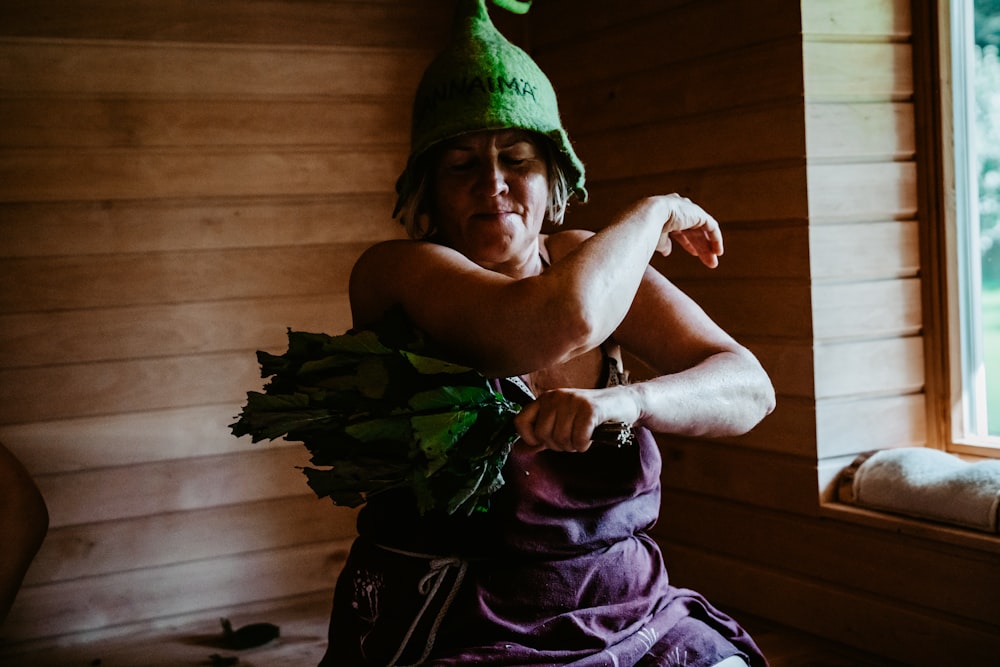a person wearing a hat and holding a plant