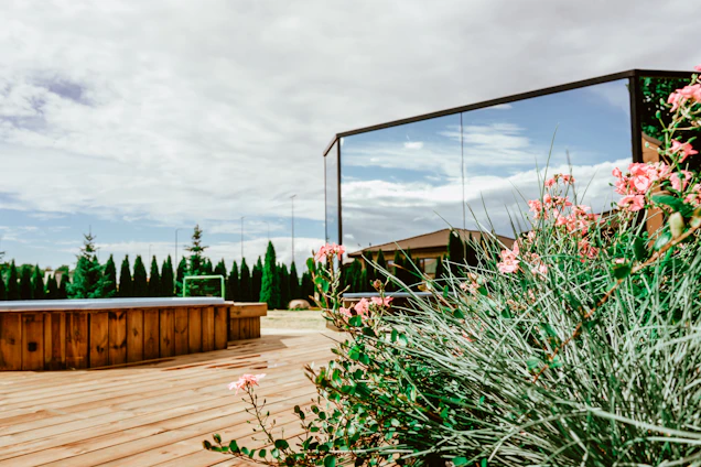 A serene backyard setting featuring a clean, modern hot tub surrounded by lush greenery at sunset.
