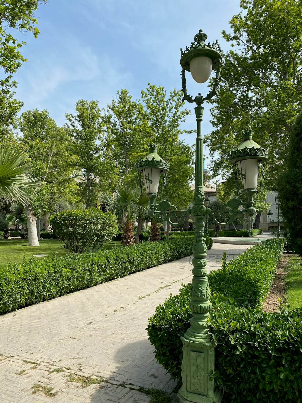 a path with lamp posts and plants