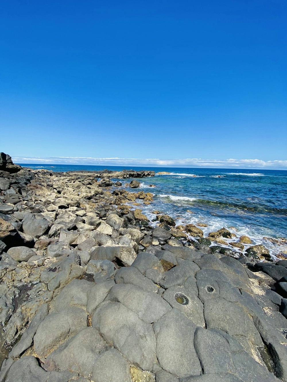 a rocky beach with blue water