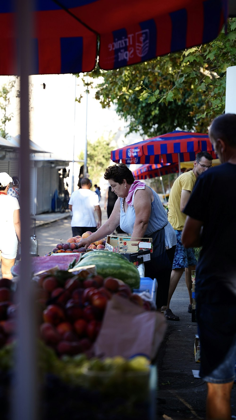 a person selling fruits at an outdoor market