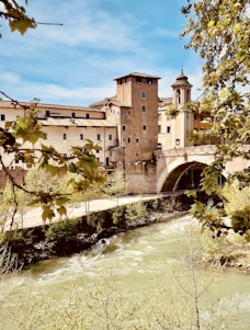 a river with a bridge and buildings