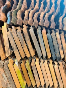 A stack of various roofing materials including shingles and tiles.