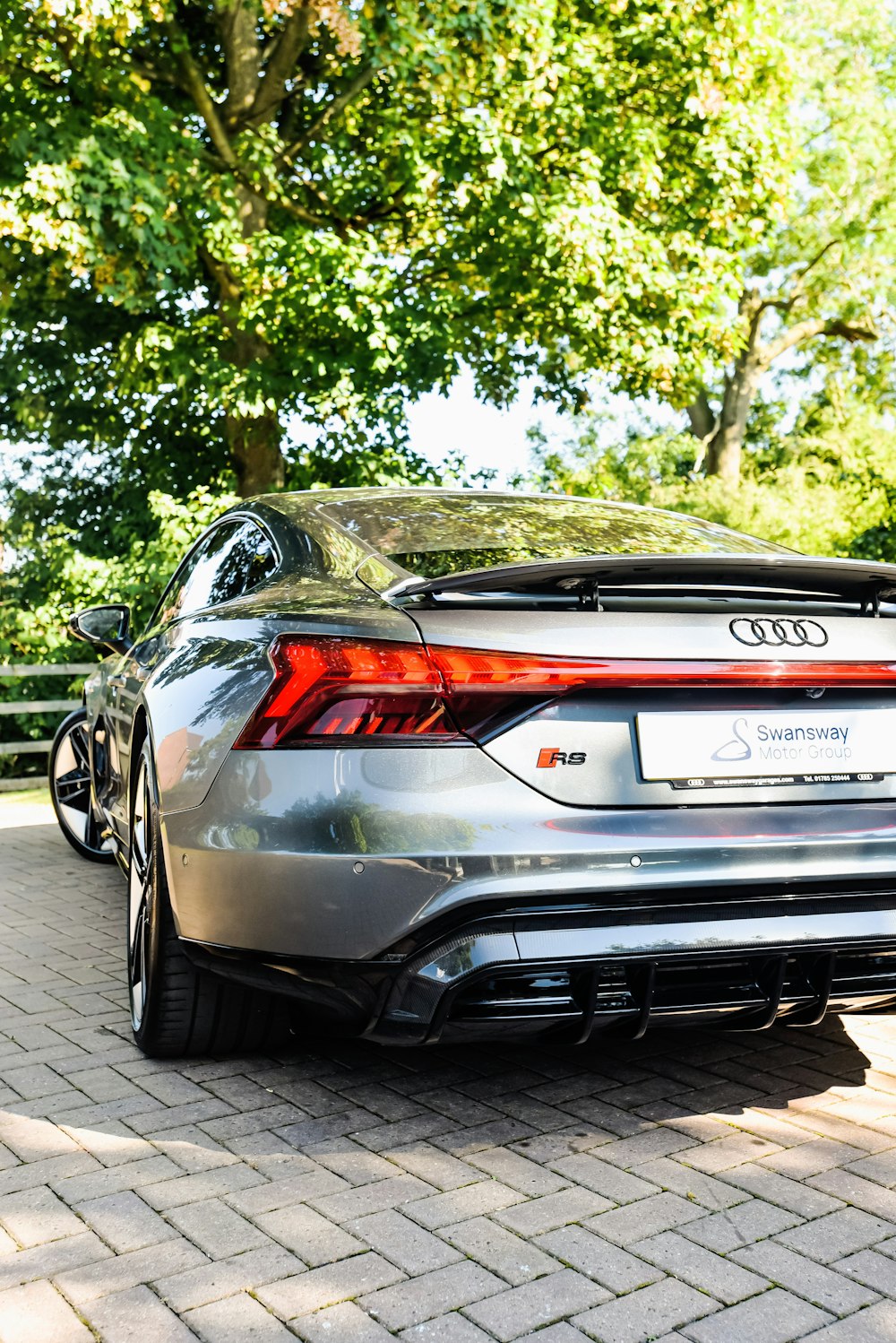 a sports car parked on a brick road