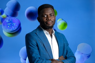 Manny Blue speaking passionately at a motivational event with a royal blue backdrop.