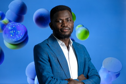 Manny Blue speaking passionately at a motivational event with a royal blue backdrop.