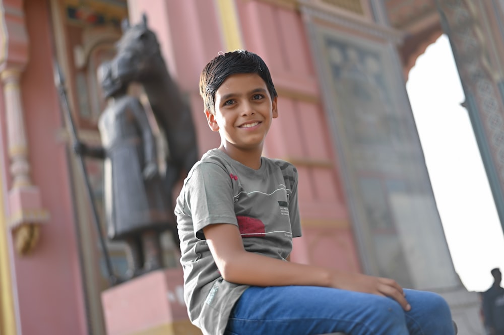 a boy sitting on a ledge