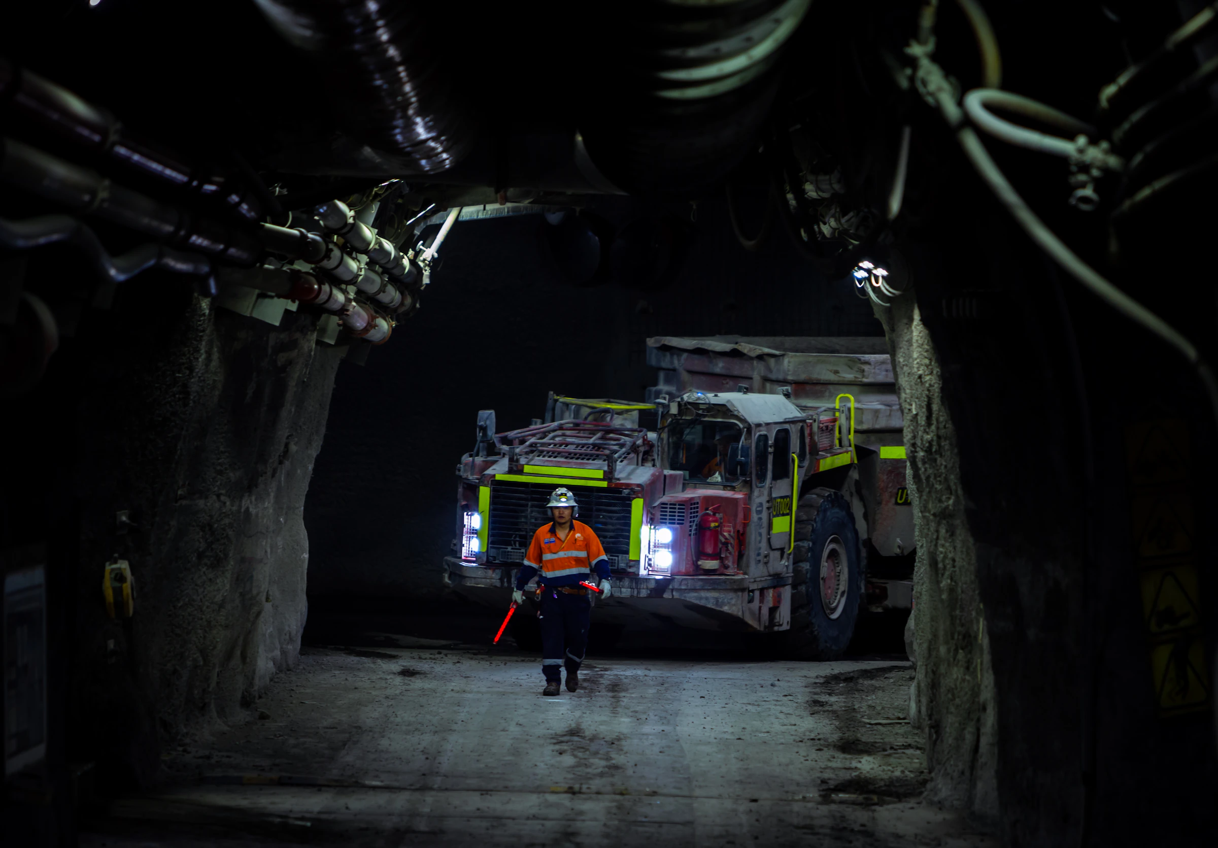 Civil engineer standing inside underground tunnel, dramatic industrial lighting and deep-bore excavation