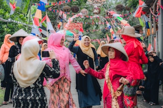 A vibrant gathering of Kurdish people celebrating together outdoors with traditional clothing.