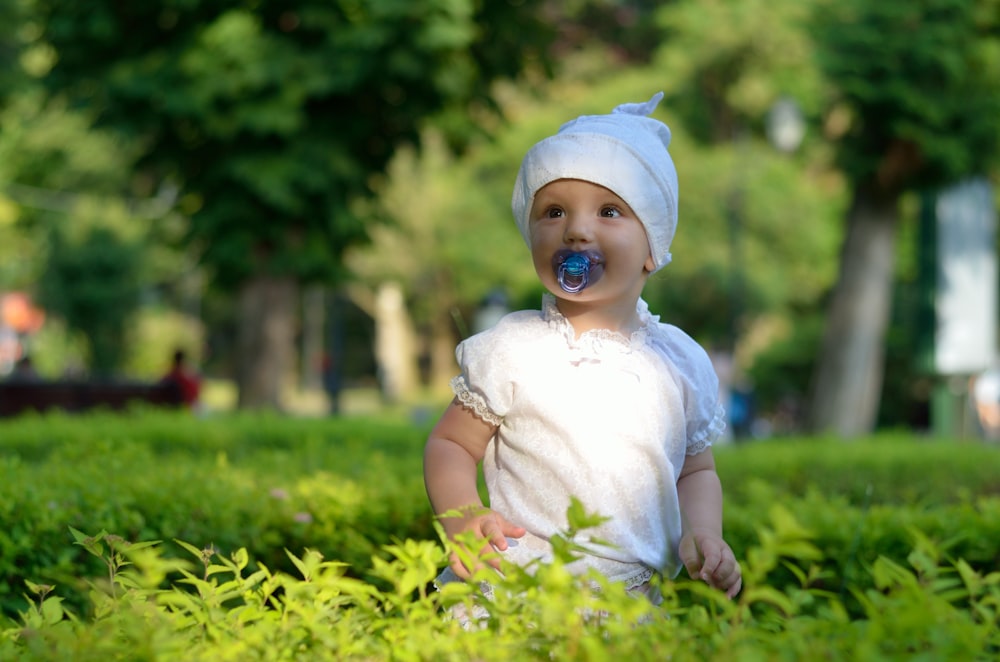 a baby sitting in the grass