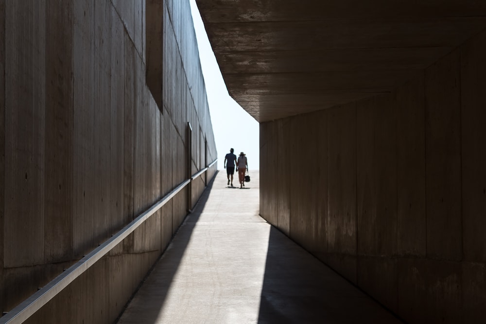 a man and a woman walking down a long hallway