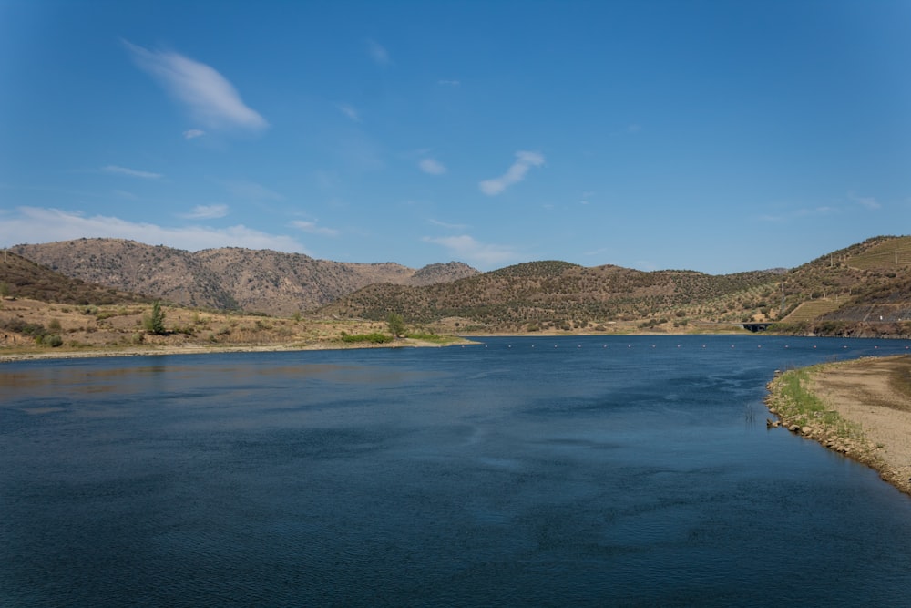 a body of water with hills in the background