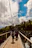 A group of hikers crossing a suspension bridge over a lush green valley.